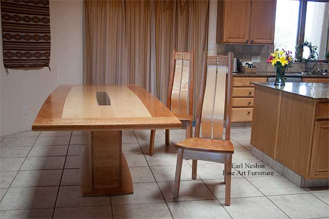 custom made contemporary dining table shown with two chairs with sculpted cherry seats